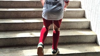 Junger Fan des 1. FC Kaiserslautern läuft Stufen empor. 