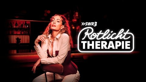 Das Keyvisual zum SWR3 Podcast "Rotlichttherapie" zeigt Domina Nina auf einem Barhocker vor einem rot beleuchteten Tresen sitzend.