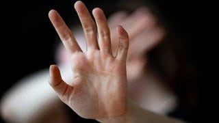 Hände, die zur Abwehr hochgehalten werden. Vor dem Mainzer Landgericht müssen sich zwei Männe rund eine Frau verantworten, weil sie einen Mann festgehalten, gedemütigt und die Videos von der Tat im Netz verbreitet haben sollen. (Symbolbild)