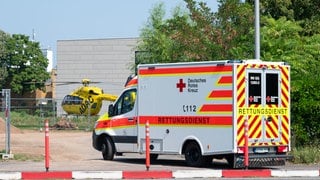 Ein Rettungswagen und ein Rettungshubschrauber stehen vor einer Baustelle. Dort wurde ein 34-Jähriger bei einem Arbeitsunfall schwer verletzt.