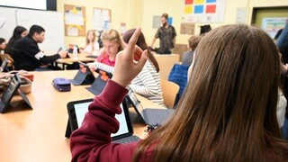 Schülerinnen und Schüler sitzen in einem Klassenraum.