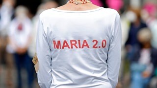 Eine Frau trägt ein T-Shirt mit der Aufschrift "Maria 2.0".