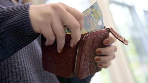 Eine Frau nimmt einen 20-Euro-Schein aus der Börse. Die Gründe für Jugendarmut.
