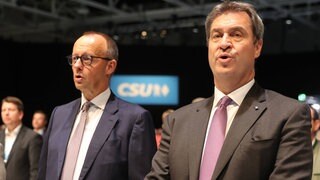 CSU-Parteitag 2022: Friedrich Merz (links) und Markus Söder singen gemeinsam die Nationalhymne