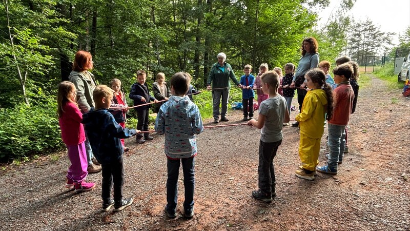 Referendarin Laura Krauß ist mit den Schülern der Grundschule Mackenbach im Wald. 
