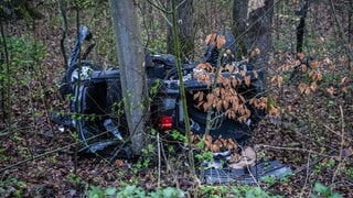 Ein schwarzes Auto liegt nach dem Unfall auf dem Dach. In Steinenbronn im Kreis Böblingen ist ein Auto ist 30 Meter die Böschung runtergestürzt.