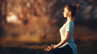 Frau macht Yoga im Herbst