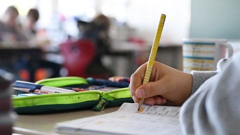Ein Schüler an einer Grundschule arbeitet in seinem Matheheft