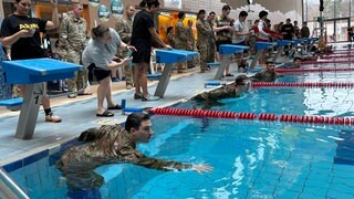 Ein Soldat in Uniform im Schwimmbecken - in Ramstein haben Soldaten von US-Militär und Bundeswehr ein spezielles Sportabzeichen gemacht