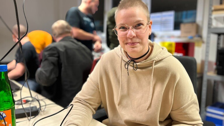 Lena Michel lötet im FabLab Bruchsal Bilder ihrer Katzen auf Küchenbretter.