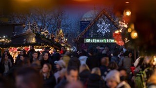 Besucher gehen über den Weihnachtsmarkt in Stuttgart 