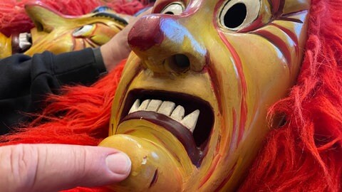 Holzmaske der Fürig Barthel: Am Kinn der Maske ist Farbe abgesplittert, was repariert werden muss.
