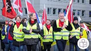Eine Gruppe Menschen mit Warn·westen und Fahnen. Die Menschen sind im Streik. Rechts das SWR Logo für Leichte Sprache.