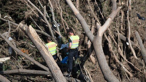 Polizisten suchen im Geröll an einer Ahrbrücke nach möglichen Opfern der Flutkatastrophe. 