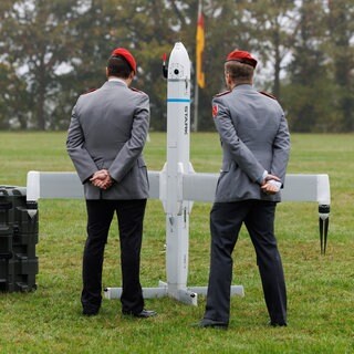 Zwei Soldaten betrachten eine Drohne der Firma Stark Defence beim Appell für das Artilleriebataillon 215 im Oktober 2025: In Deutschland sind Dutzende neue Rüstungs-Start-ups entstanden. Kritiker halten die Produkte für gefährlich.