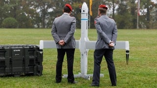 Zwei Soldaten betrachten eine Drohne der Firma Stark Defence beim Appell für das Artilleriebataillon 215 im Oktober 2025: In Deutschland sind Dutzende neue Rüstungs-Start-ups entstanden. Kritiker halten die Produkte für gefährlich.