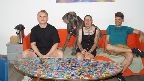 Das Team der Streetworker, dass das Projekt in Kaiserslautern unterstütz, sitzt auf einem Sofa.
