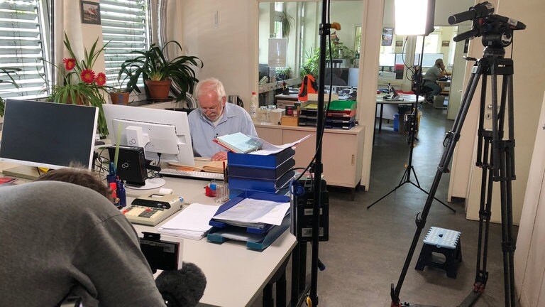 Filmaufnahmen im Büro: Eisenbahn-Betriebsleiter Manfred Richter stöbert in alten Unterlagen von der Hafenbahn. 