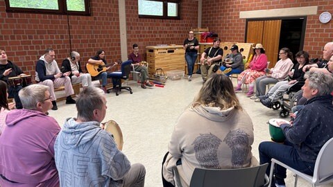 Ergotherapeutin Dorothee Rometsch spielt Gitarre bei einem Mitmach-Musikkurs in der Stiftung Scheuern. 