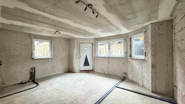 Eine Wohnungstür. Drumherum eine Wohnung im Rohzustand.