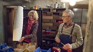 Kati präsentiert Karl im Brunnengang eine riesige Blumenvase