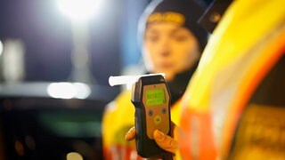 Eine Polizistin misst den Alkoholwert eines Autofahrers (Symbolbild). In Heilbronn ist ein Fahrer mit vier Promille in Heilbronn geflüchtet. Zuvor hatte seine Komplizin eine Tankstelle ausgeraubt.