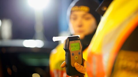 Eine Polizistin misst den Alkoholwert eines Autofahrers (Symbolbild). In Heilbronn ist ein Fahrer mit vier Promille in Heilbronn geflüchtet. Zuvor hatte seine Komplizin eine Tankstelle ausgeraubt.