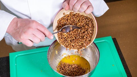 Für das Rezept mit dem Butternut-Kürbis werden die Alblinsen dem Salatdressing hinzugegeben und untergerührt.