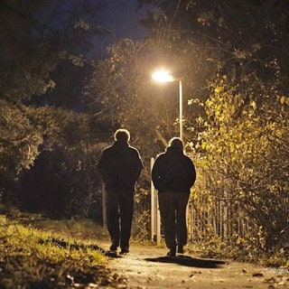 2 Menschen laufen auf dunklem Weg