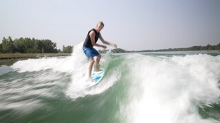 Wakesurfer Meo Stirm surft auf den Wellen des Rheins und balanciert auf seinem Board.