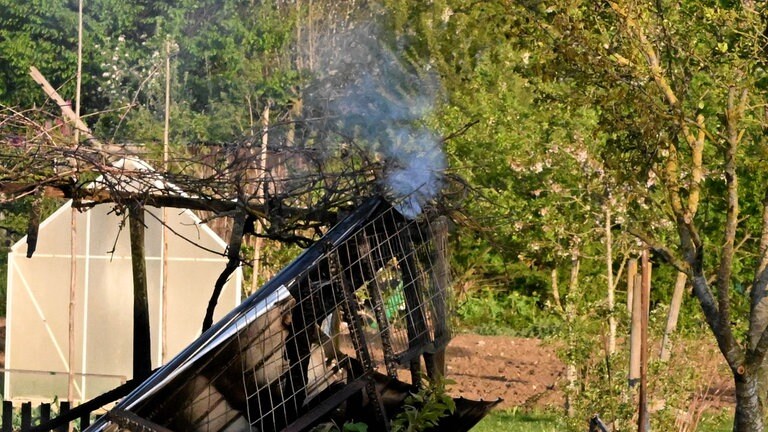 Verkohlte Holzreste. Von sieben Gartenhütten ist nach dem Brand in der Kleingartenanlage in Langenau nicht mehr viel übrig. 