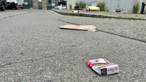 Alter Müll: eine Zigarettenschalten und ein Karton, in dem Alkohol gelagert wurde. Mögliche Überbleibsel der Partynacht und des Nabadas am Schwörmontag in Ulm. 