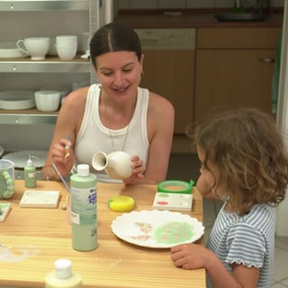 Eine Familie bemalt Keramik.