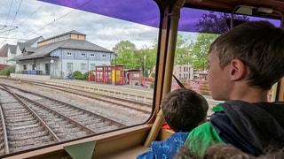 Kinder sitzen in der Führerstand eines Zuges und werden durch Trossingen gefahren.