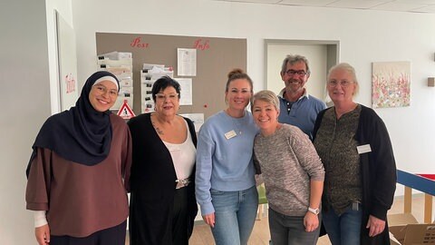 Gruppenbild der Mitarbeiter der WG für Menschen mit Demenz in Alzey, gemeinsam mit einem Angehörigen.