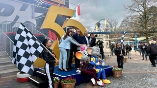 Familie Mack posiert mit den Maskottchen des Europa-Parks vor einer goldenen 50.
