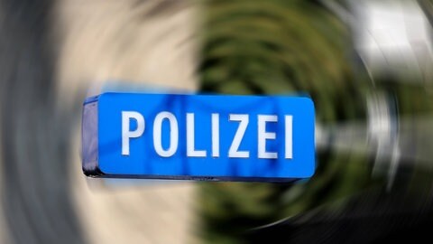 Zu lesen ist "Polizei" vor einem verwirbelten, verschwommenen Hintergrund