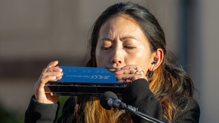 Frau spielt auf Bass-Mundharmonika