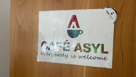 Das Logo der Flüchtlingshilfe im Café Asyl Landau. Hier arbeitet die Landauer Flüchtlingshelferin Magdalena Schwarzmüller.