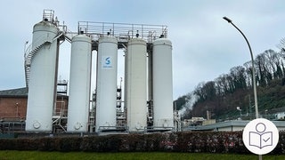 Fünf weiße Gas·türme der Firma Solvay in Bad Wimpfen. Bei der Chemie-Firma soll Treibhaus·gas ausgetreten sein. Rechts das SWR Logo für Leichte Sprache.