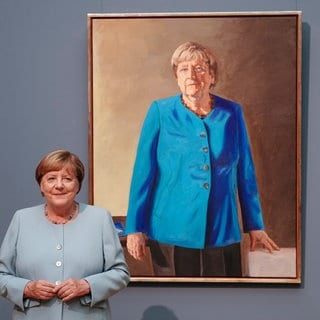 Angela Merkel, ehemalige Bundeskanzlerin, steht vor ihrem Porträt 