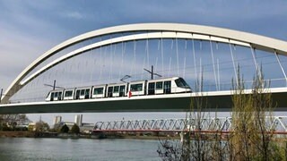 Eine Straßenbahn fährt auf der Beatus Rhenanus Brücke über den Rhein von Straßburg nach Kehl.
