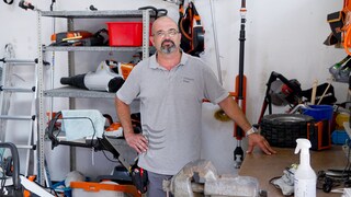 Hausmeister Carlos steht in seinem Werkzeuglager im Stuttgarter Schwimmbad Leuze. Er trägt ein graues Polohemd. Hinter ihm sind verschiedene Gartengeräte zu sehen.