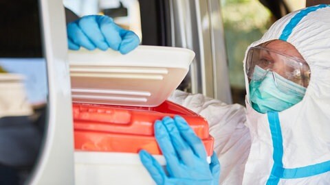 Eine Medizinerin in Schutzkleidung überprüft eine Organspende (Symboldbild). 