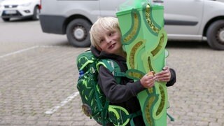 Mit einer großen Schultüte und einem Schulrucksack steht der 6-jährige Oscar kurz vor seiner Einschulung.