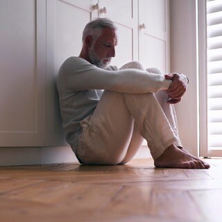 Symbolbild für Altersdepression. Ein Mann sitzt auf dem Boden und wirkt dabei sehr niedergeschlagen. Psychiaterin Katharina Domschke spricht in SWR1 Leute über Depression und wie sie behandelt wird.