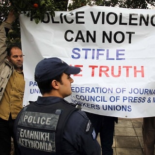 Local photo-reporters hold a banner outside the Presidential Mansion in Athens, Greece, April 11, 2012. Greek press unions staged new protests on Wednesday over the injury of a Greek photojournalist by police during an anti-austerity protest in Athens last week, calling for justice.