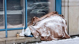 Schneebedeckter Schlafplatz eines Obdachlosen am Bürgersteig. Trotz Schnee und Eis suchen nicht alle Betroffenen Hilfe in Notunterkünften.