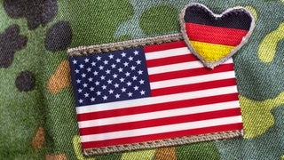Militäruniform mit US-Flagge und Deutschlandflagge in Herzform als Aufnäher auf dem Ärmel