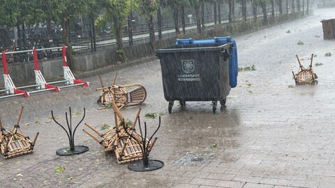 Umgestürzte Tische und Stühle liegen in Friedrichshafen auf der Straße.